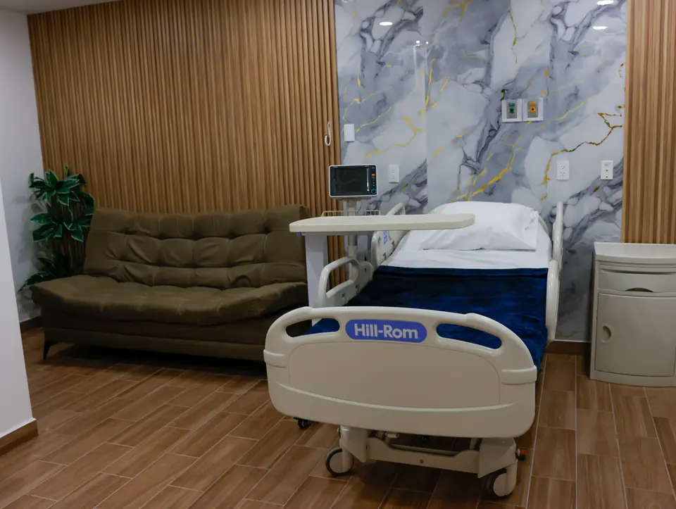 Habitación de hospitalización con cama Hill-Rom, monitor y sofá para acompañante