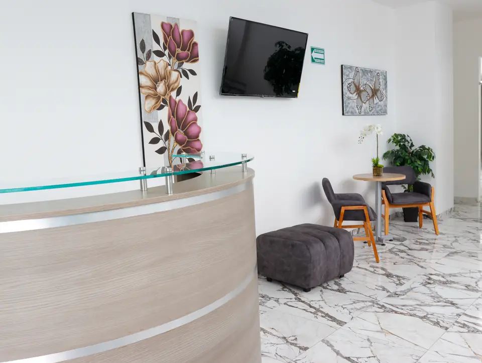 Recepción y sala de espera con sillones y mármol